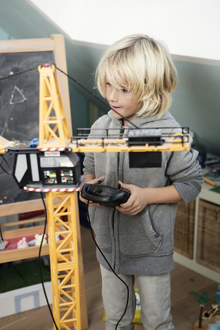 Blonder Junge spielt mit Spielzeugkran, lizenzfreies Stockfoto