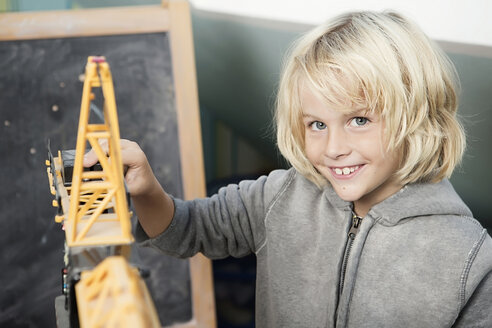 Blond boy playing with toy crane - GDF000234