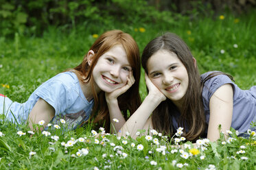 Mädchen liegen auf einer Blumenwiese - LB000351