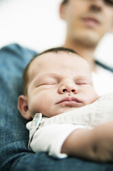Junger Vater hält seinen schlafenden neugeborenen Sohn - JATF000382
