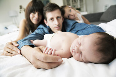Junge Eltern mit kleiner Tochter und neugeborenem Sohn zu Hause - JATF000402