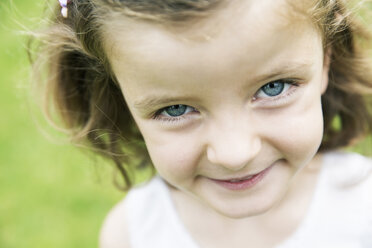 Smiling little girl with blue eyes watching at camera - JATF000413
