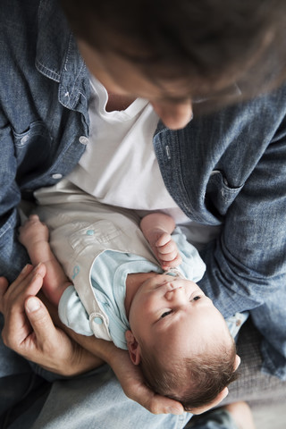 Junger Vater hält seinen neugeborenen Sohn, lizenzfreies Stockfoto