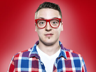 Portrait of young man with red glasses, studio shot - STKF000401