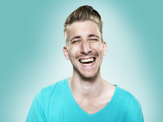 Portrait of laughing young man, studio shot - STKF000413