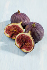 Sliced and whole figs on wooden table, studio shot - CSF020192