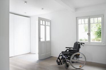 Germany, Cologne, Wheel chair in empty room - PDF000523