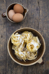 Ungekochte Tagliatelle und Eier auf dem Holztisch - LVF000246