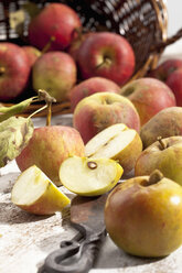 Bio-Äpfel (Malus), Korb und ein Messer auf weißem Holztisch, Studioaufnahme - CSF020298