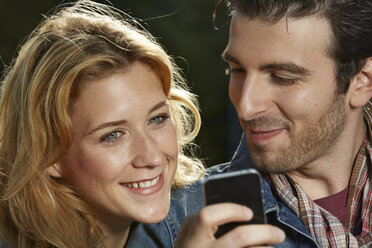 Germany, Dusseldorf, Young couple with mobile phone - STKF000418