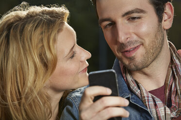 Germany, Dusseldorf, Young couple with mobile phone - STKF000419