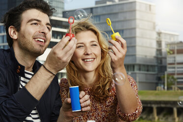 Germany, Dusseldorf, Young couple making soap bubbles - STKF000442