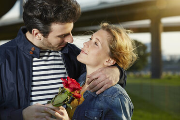 Germany, Dusseldorf, Young couple with red rose - STKF000449