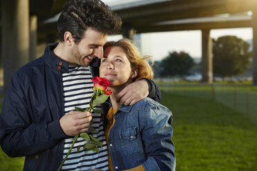 Germany, Dusseldorf, Young couple with red rose - STKF000450