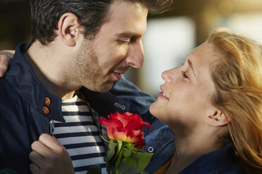 Germany, Dusseldorf, Young couple with red rose - STKF000451