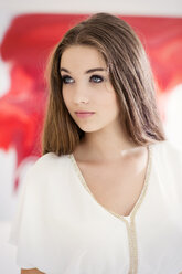 Portrait of serious looking teenage girl in front of a red painting - GDF000282