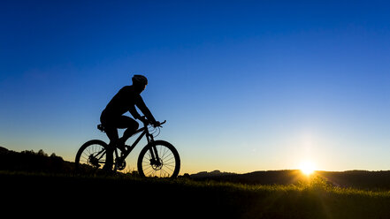 Deutschland, Winterbach, Radfahrer auf einem Mountainbike bei Sonnenuntergang - STSF000190