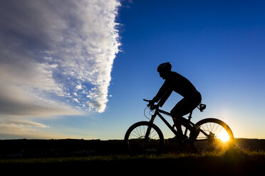 Deutschland, Winterbach, Radfahrer auf einem Mountainbike bei Sonnenuntergang - STSF000189