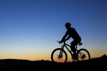 Deutschland, Winterbach, Radfahrer auf einem Mountainbike bei Sonnenuntergang - STSF000184