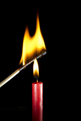 Burning candle with matchstick - PSAF000012