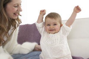 Lächelndes kleines Mädchen mit ausgestreckten Armen neben ihrer Mutter - FSF000021