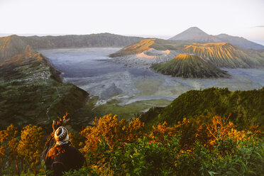 Indonesien, Java, Bromo Tengger Semeru National Park, Tourist blickt auf den Vulkan Bromo hinunter - MBEF000801
