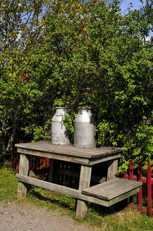 Sweden, Smaland, Milk churns on wooden table - BTF000036