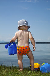 Kleiner Junge mit Gießkanne vor einem See - RDF001198