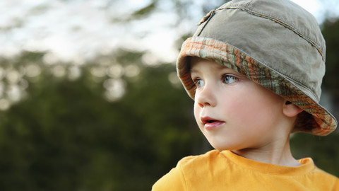 Porträt eines spielenden kleinen Jungen mit Sonnenhut, lizenzfreies Stockfoto