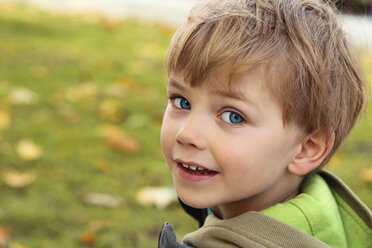 Porträt eines lächelnden kleinen Jungen, der über seine Schulter schaut - RDF001217