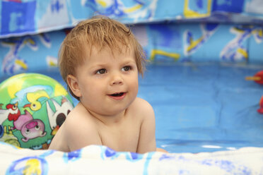 Porträt eines lächelnden kleinen Jungen im Pool - RDF001220