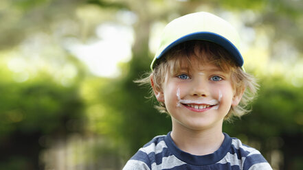 Porträt eines lächelnden kleinen Jungen mit Milchschnurrbart - RDF001221