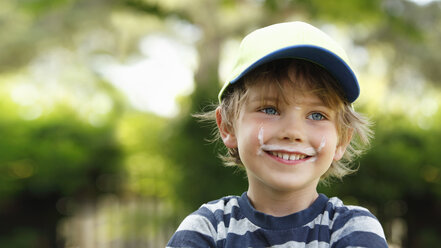 Porträt eines lächelnden kleinen Jungen mit Milchschnurrbart - RDF001222