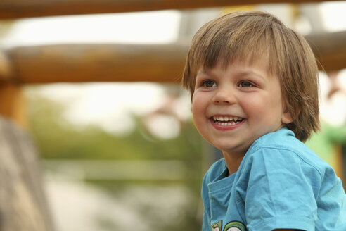 Porträt eines lächelnden kleinen Jungen auf dem Spielplatz - RDF001227