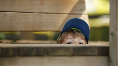 Little boy hiding at playground stock photo