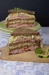 Vollkornbrot-Sandwiches mit Schinken, gerösteten Zucchini, Tomaten und Käse auf Teller und Schneidebrett, garniert mit Kresse, Studioaufnahme - ODF000625
