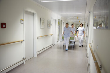 Deutschland, Freiburg, Krankenschwestern bewegen Krankenhausbett - DHL000134