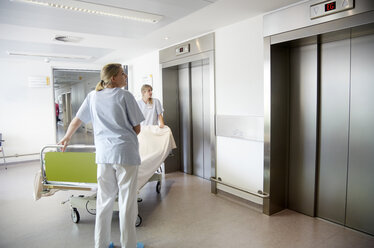 Deutschland, Freiburg, Krankenschwestern bewegen Krankenhausbett - DHL000125