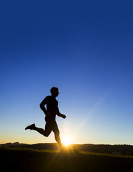 Deutschland, Winterbach, Jogger bei Sonnenuntergang - STSF000202