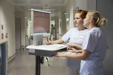 Deutschland, Freiburg, Krankenschwestern und -pfleger mit mobilen Computern bei der Überprüfung von Patientendaten - DHL000147