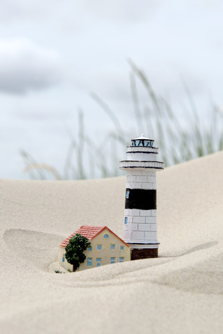 Deutschland, Amrum, Modelle von Leuchtturm und Haus im Sand, lizenzfreies Stockfoto