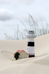 Deutschland, Amrum, Modelle von Leuchtturm und Haus im Sand - AWDF000726