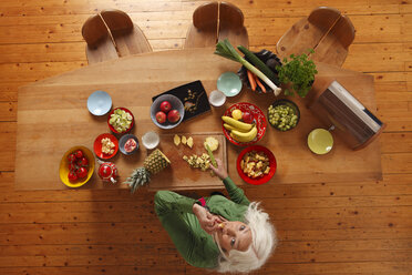 Germany, Dusseldorf, Senior woman preparing raw food - UKF000238