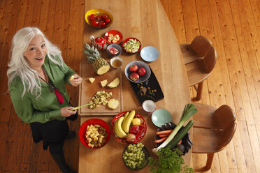 Germany, Dusseldorf, Senior woman preparing raw food - UKF000252