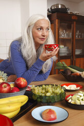 Germany, Dusseldorf, Senior woman with raw food drinking tea - UKF000233