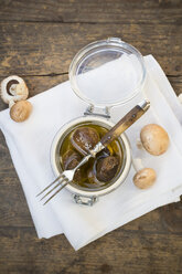 Frische und eingelegte braune Pilze (Agaricus) auf Holztisch, Studioaufnahme - LVF000305