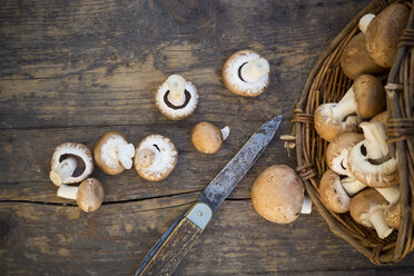 Fresh brown mushrooms (Agaricus), basket and a pocketknife on wooden table, studio shot - LVF000300