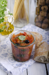 Geleeglas mit Tomatensauce, schwarzen Oliven und Basilikumblättern, serviert mit Weißbrot, Studioaufnahme - ODF000649