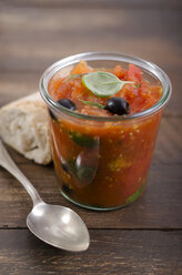 Geleeglas mit Tomatensauce, schwarzen Oliven und Basilikumblättern, serviert mit Weißbrot, Studioaufnahme - ODF000648