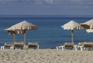 Spain, Formentera, Es Arenals, sunshades and beach chairs - CM000018